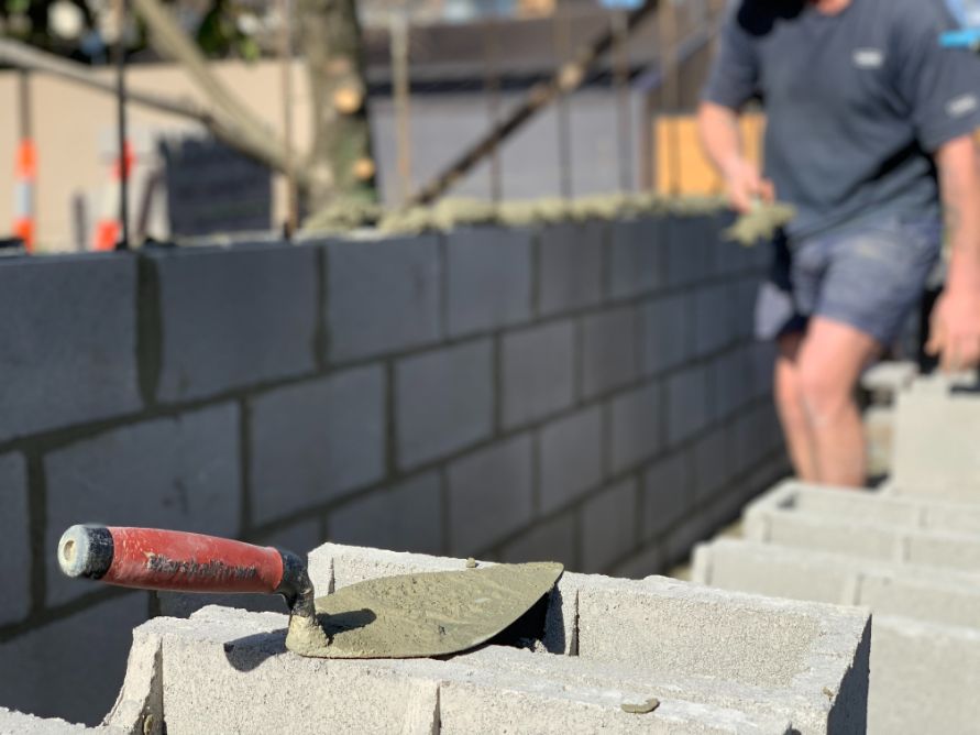Bricklayer working on a block fence in Woombye, Sunshine Coast