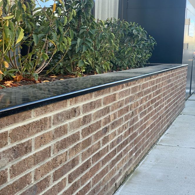 A brick planter box with leafy plants in Meridan Plains, Sunshine Coast