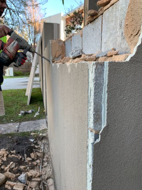 A damaged brick fence in Buddina being removed to be replaced with a decorative brick fence